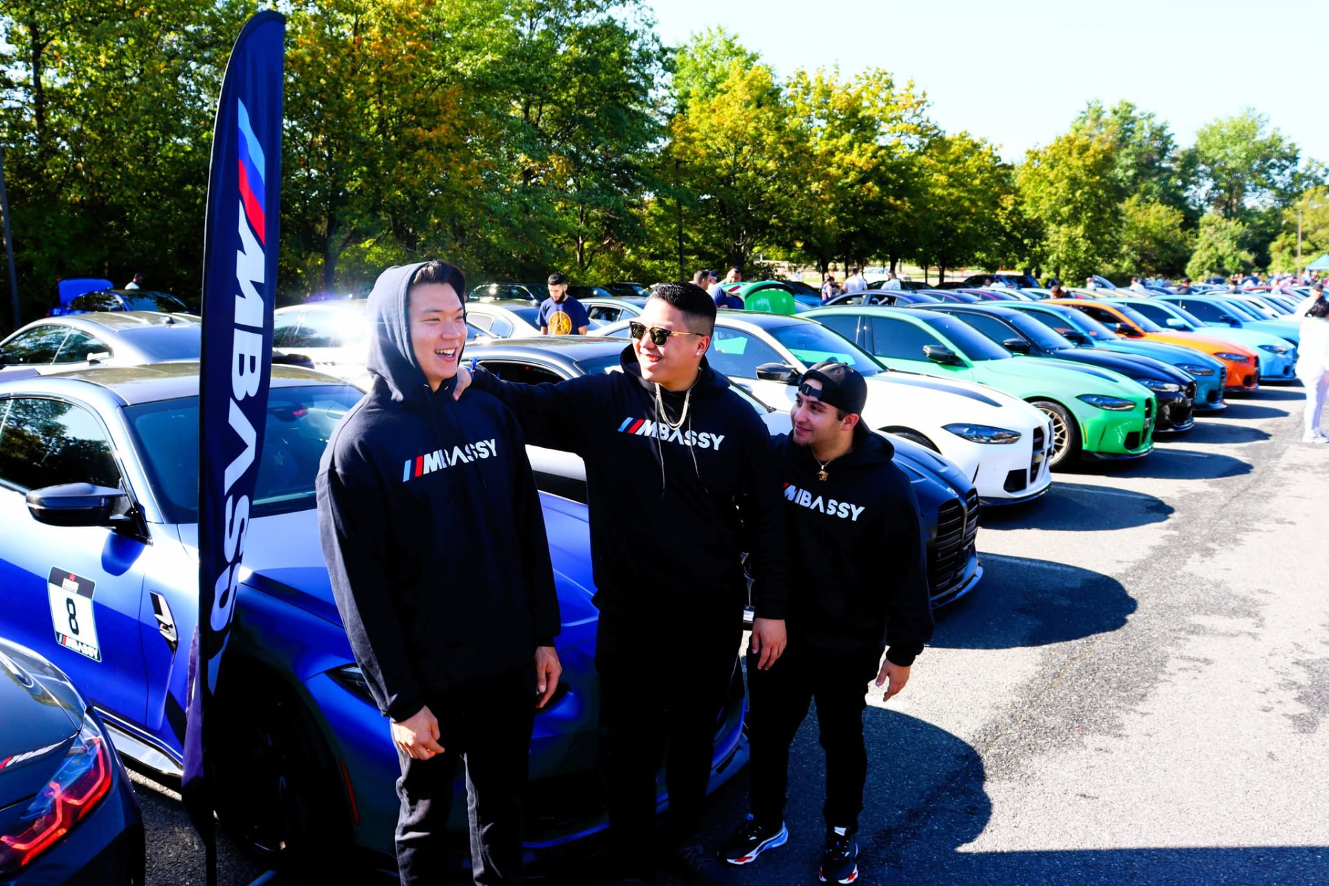 Enthusiasts in front of a long row of colorful BMW M cars
